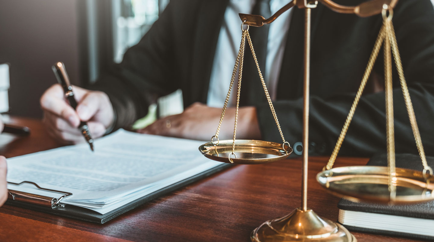 Juriste examinant les clauses d'un contrat de portage salarial avec une loupe dans un bureau d'avocat